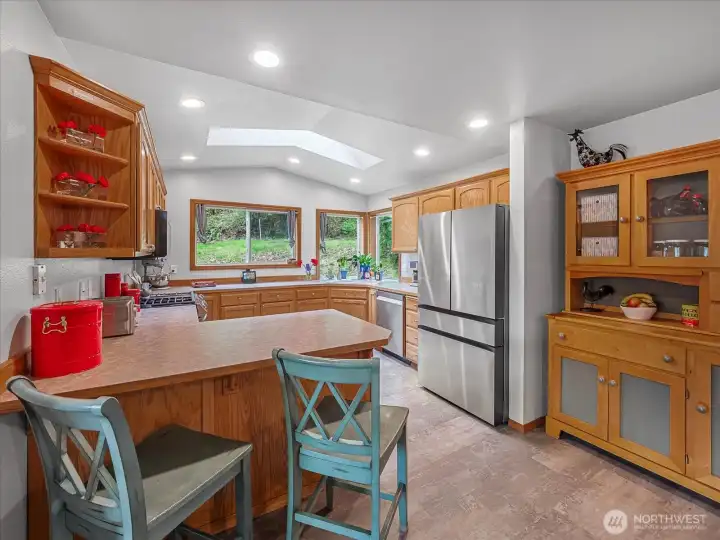 Eat-in kitchen with bar and stainless steel appliances.