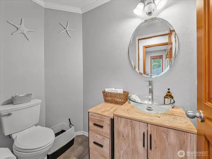 Powder room has crown molding and newer vanity.