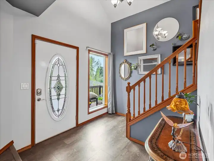 Spacious entryway with stairs offset from the front door, coat closet and half-closet are in the nearby hallway.