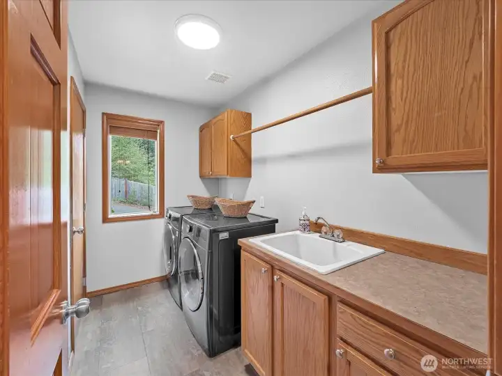 Laundry room with two closets, storage, folding counter, and utility sink.