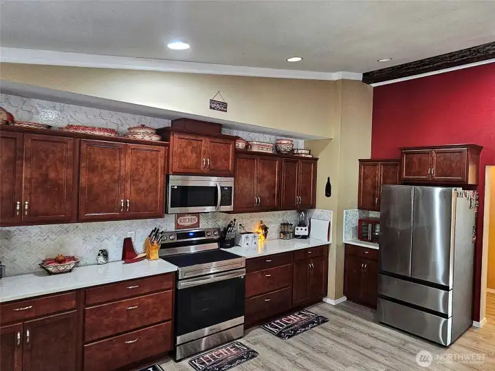 Large kitchen with quartz countertops, new stainless steel appliances and custom cabinets.