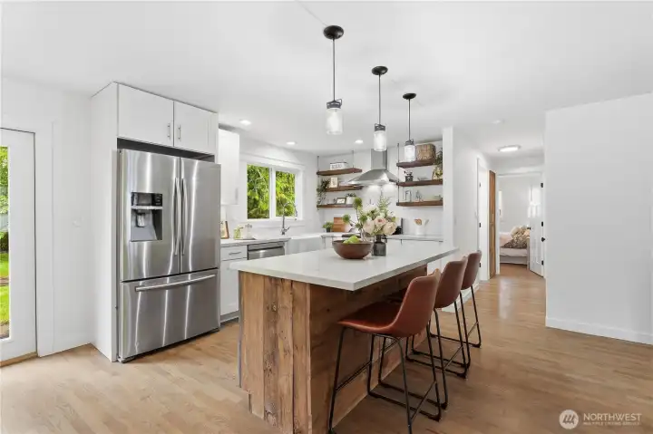 Gather around the barnwood-wrapped island featuring an inviting eat-in bar ideal for everyday living and entertaining.