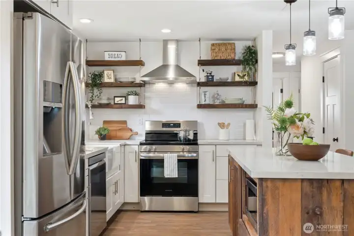 Custom barnwood open shelving creates a stunning focal point in the kitchen, adding warmth and character.