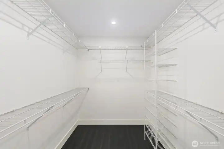 A generous walk-in closet offers ample storage with built-in hanging space and shelving.