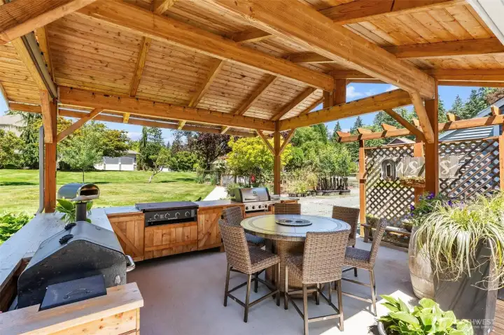 Outdoor Kitchen    Outdoor Living at Its Best    Complete with a built in barbecue, Blackstone griddle, smoker, and generous entertaining space, this outdoor kitchen was designed to bring people together.