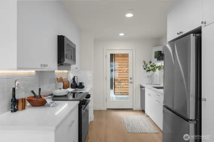 Photos of model home with similar finishes & floor plan. Your future kitchen, where form meets function! Clean lines, natural light, and direct access to the outdoors—it’s the recipe for your best meals yet.