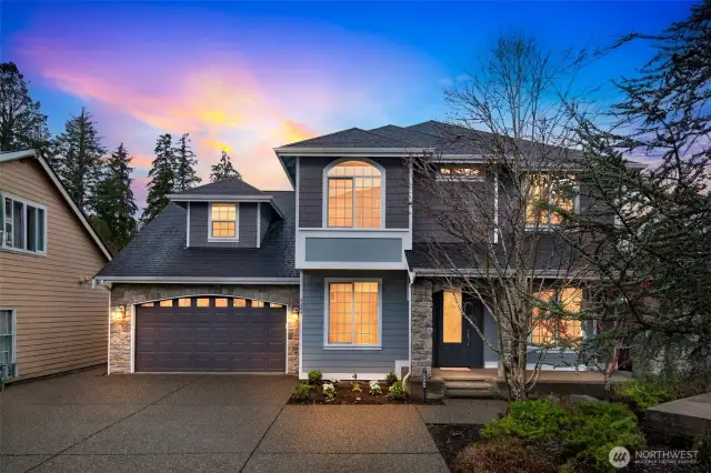 Stunning curb appeal with stone accents, modern lines, and warm evening glow welcomes you home.
