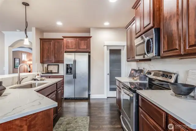 This chef’s kitchen blends form and function with quartz countertops, warm cabinetry, walk-in pantry and upscale stainless steel appliances. Whether you're hosting friends or savoring a quiet night in, it all begins here.