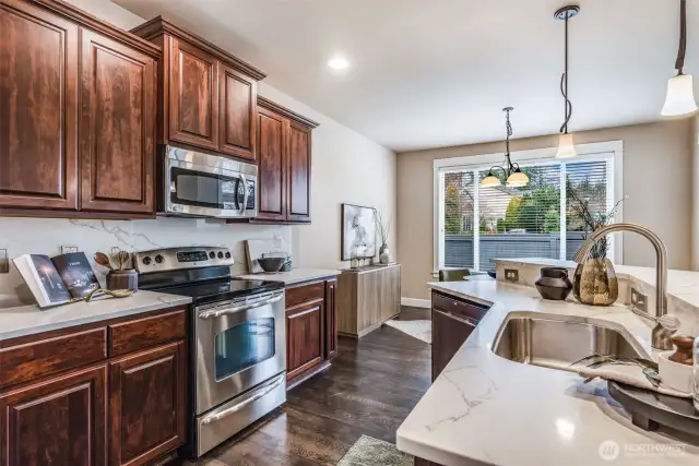 Open-concept kitchen flows seamlessly into the sunlit breakfast nook & den.