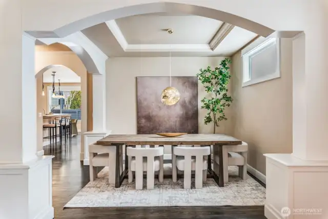 Beautifully framed formal dining room w/coffered ceilings & arched columns, perfect for stylish entertaining.