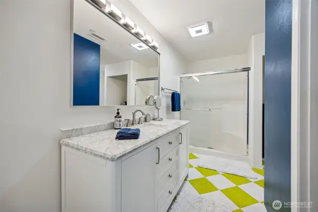 Primary bath features custom vanity, shower and walk in closet.  Additional Linen storage around the corner.