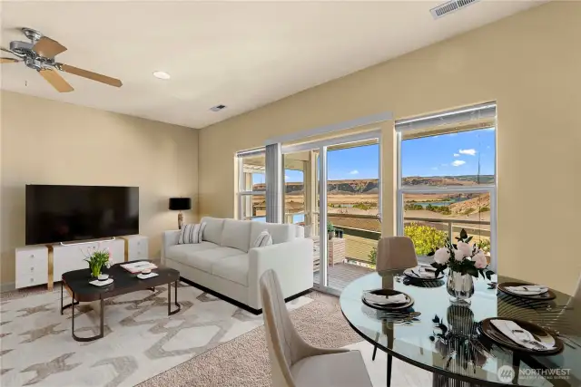 Spacious living room with natural light, picture windows, and open flow to dining and kitchen
