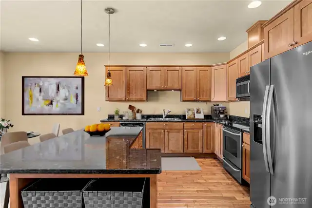 Gourmet kitchen with warm wood cabinetry, full appliance suite, and ample counter space