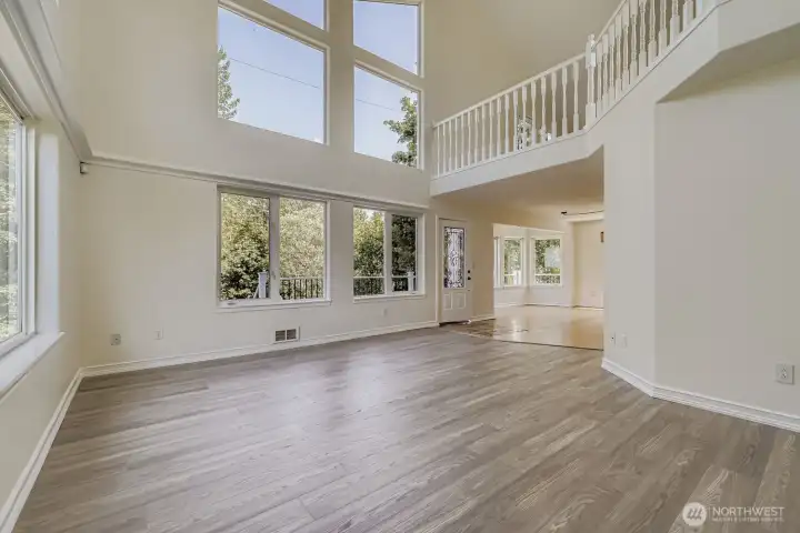 Large family/living room with expansive windows & views of treetops