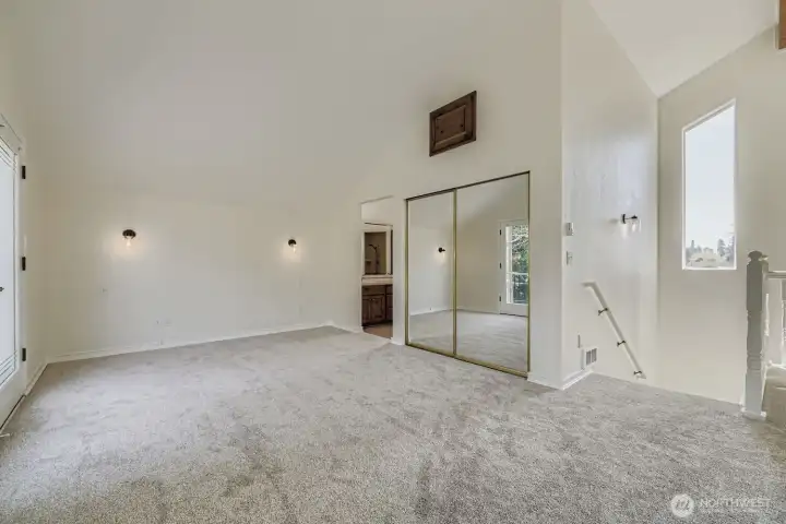 Primary suite and balcony with windows overlooking the trees or river views