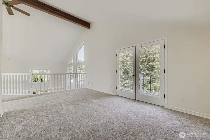 Primary suite and balcony with windows overlooking the trees or river views