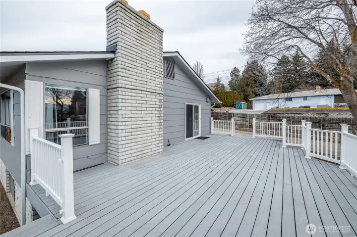 Imagine hosting or relaxing on this spacious deck under the shade trees