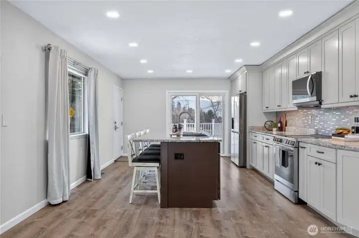 Large island and slider out to deck for awesome parties or BBQs - you know everyone hangs out in the kitchen! Exterior door to the left goes to back driveway area.