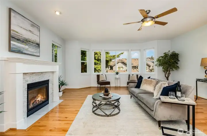 Extra large living area with many windows, ceiling fan and cozy gas fireplace