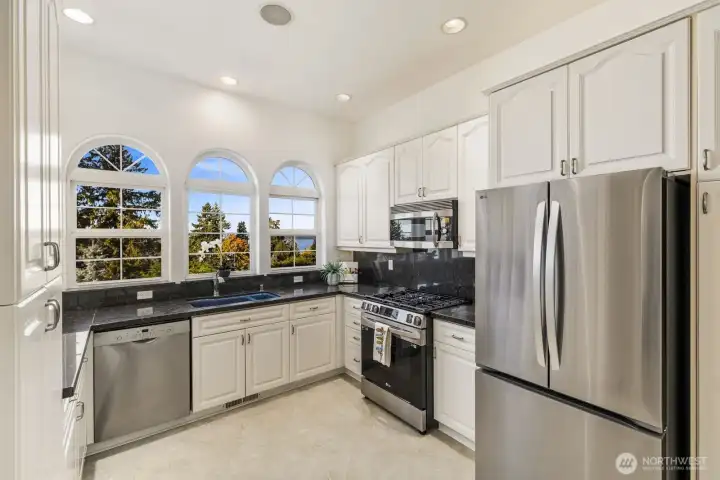 Stainless steel appliances, rich stone counters, and functional storage throughout.