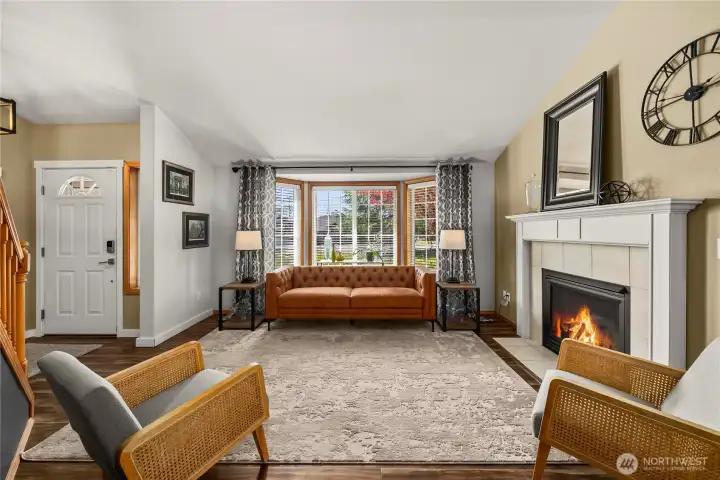 Formal living room featuring a cozy fireplace and bay window.