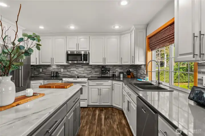 The mosaic backsplash paired with quartz countertops adds texture, style, and a polished finish that makes this kitchen stand out.