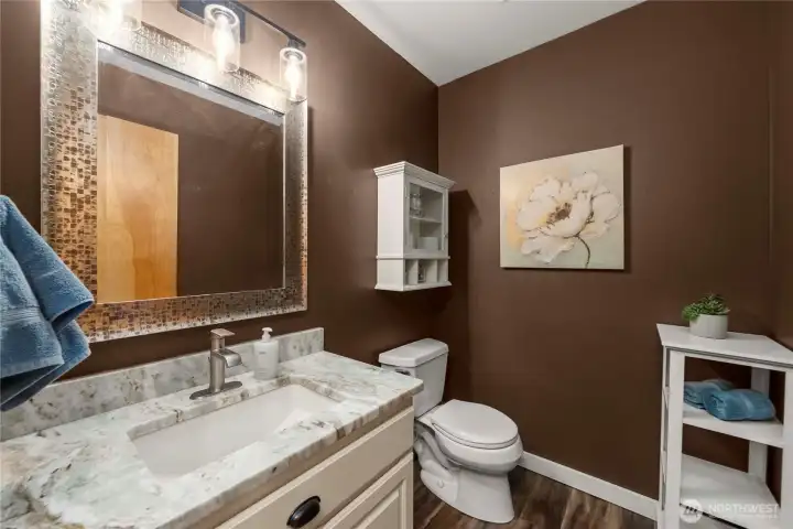 Downstairs powder room with upgraded lighting and a custom cabinet adds a thoughtful, elevated touch.