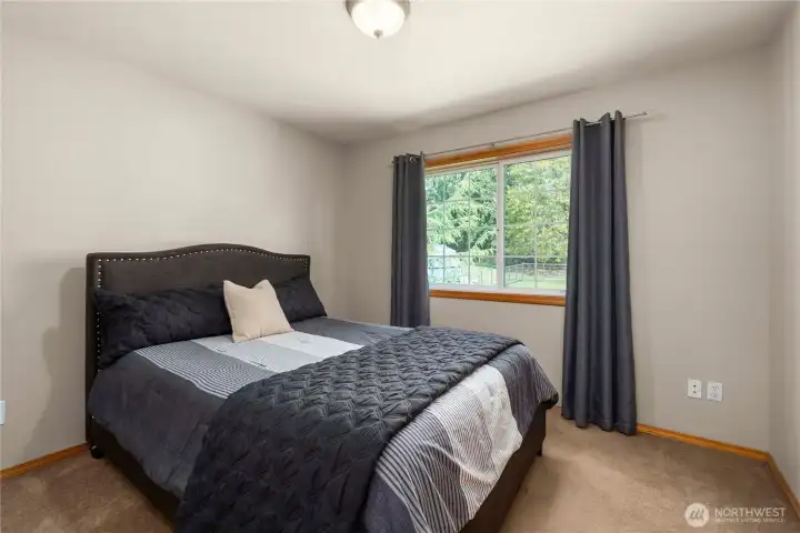 Bedroom three enjoys a nice backyard view, bringing in a calm, natural backdrop.