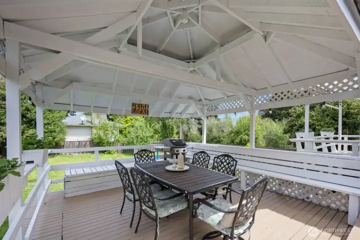 Additional covered porch with plenty of seating for hosting and outdoor dining.