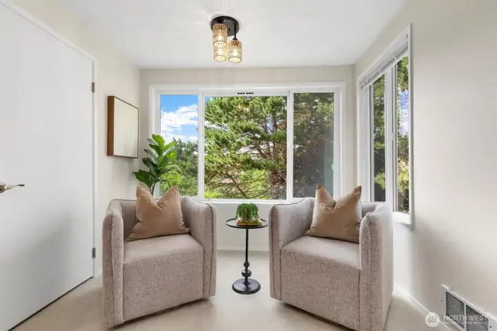 The reading nook looks out at a grass yard, a large pine tree with wildlife bounding about, and a green belt. The reading nook looks out at a grass yard, a large pine tree with wildlife bounding about, and a green belt.