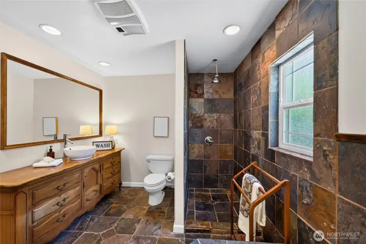 The expansive vanity provides abundant counter space while adding to the unique character of this beautifully designed bath. The expansive vanity provides abundant counter space while adding to the unique character of this beautifully designed bath.