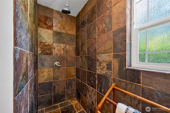 A spacious tiled walk-in shower with a privacy wall creates a spa-like experience. A spacious tiled walk-in shower with a privacy wall creates a spa-like experience.