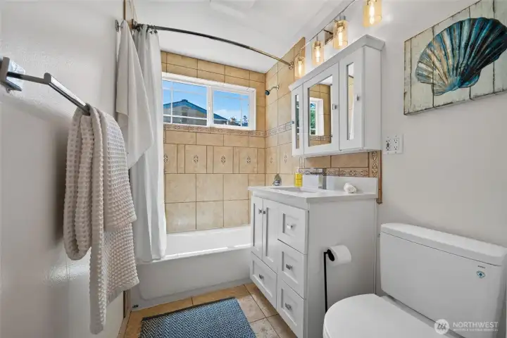 Natural light, a tiled tub surround, and thoughtful finishes make this bathroom warm and welcoming Natural light, a tiled tub surround, and thoughtful finishes make this bathroom warm and welcoming