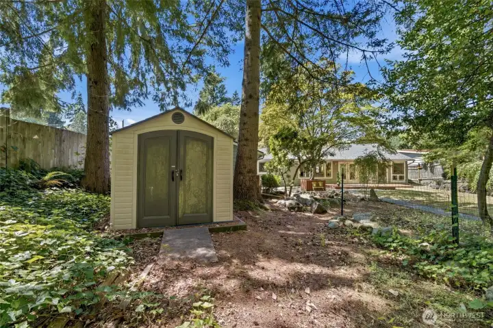 A charming garden shed adds extra storage and complements this beautifully landscaped backyard retreat. A charming garden shed adds extra storage and complements this beautifully landscaped backyard retreat.