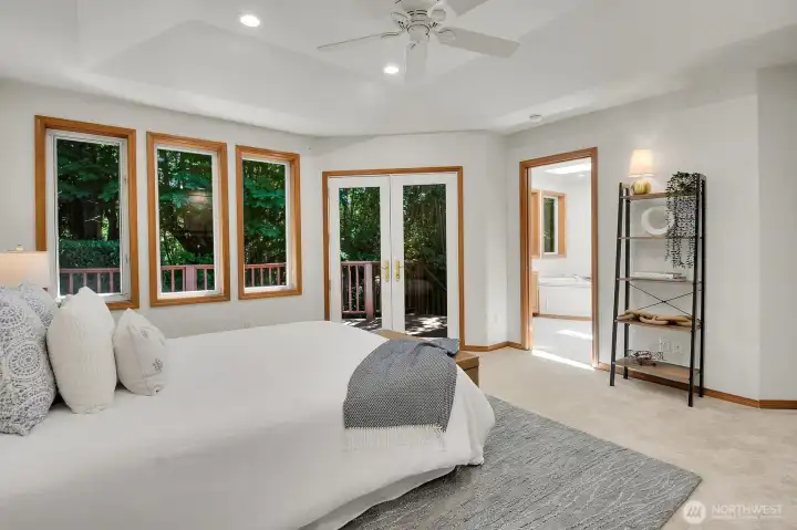 French doors open to a private deck overlooking the lush greenbelt.