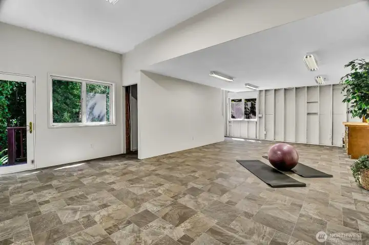 The expansive lower-level Dream Room with fresh paint and new vinyl flooring offers endless possibilities for a home gym, media room, hobbies, recreation, or multi-purpose living.