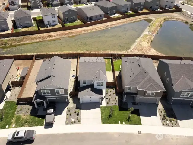 Aerial front of home with pond.