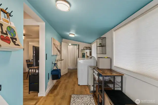 Front entry with washer/dryer and hooks for clam gun storage.