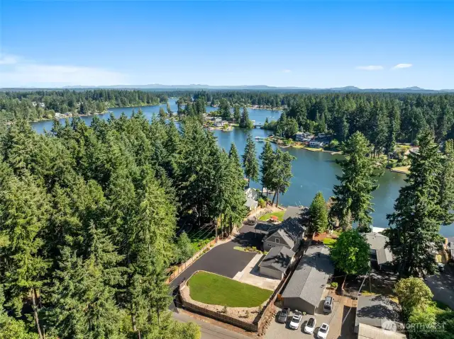 Welcome to your waterfront compound. The newly paved driveway opens up to a spacious area that checks every box, from the 4-car garage to the flat grassy lawn that’s ready for anything from playsets to pergolas. Surrounded by mature trees and lake views that stretch for days, this is the kind of property that gives you privacy without isolation. Pride of ownership echoes from every home in view, but this one stands apart with space, access, and flexibility to use it exactly how you want.