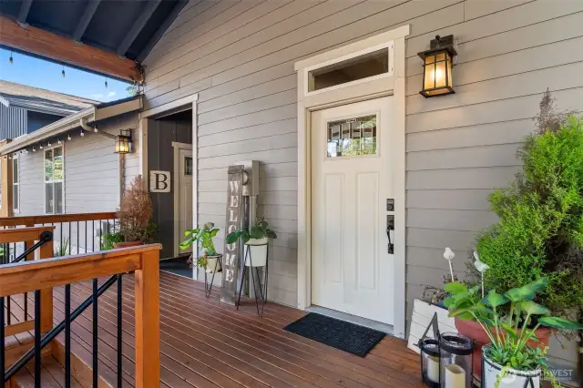The front porch does more than just welcome, it multitasks. With space for seating, planters, and a full-on holiday display, it connects the main home's inviting entry with the private access to Unit B at the far end. Gray siding, rich wood tones, and black iron accents bring a clean, contemporary style that still feels warm and personal.
