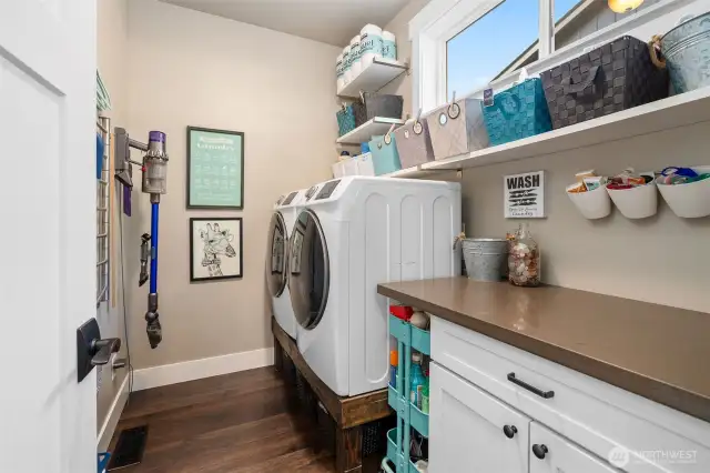 Say goodbye to laundry day blues. The high-efficiency washer and dryer sit on pedestals for easy access, while a folding counter doubles as a workspace for crafts or wrapping. Shelving keeps supplies neat, and an upper window brings in natural light and ventilation .