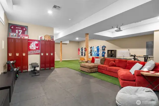Sporty padded flooring meets entertainment with a ceiling-mounted projector that stays with the home. Whether you’re hosting movie marathons or workout sessions, this versatile rec room has you covered. Furniture negotiable for your personal touch.  I could do without the WSU flag myself.  Go Dawgs!