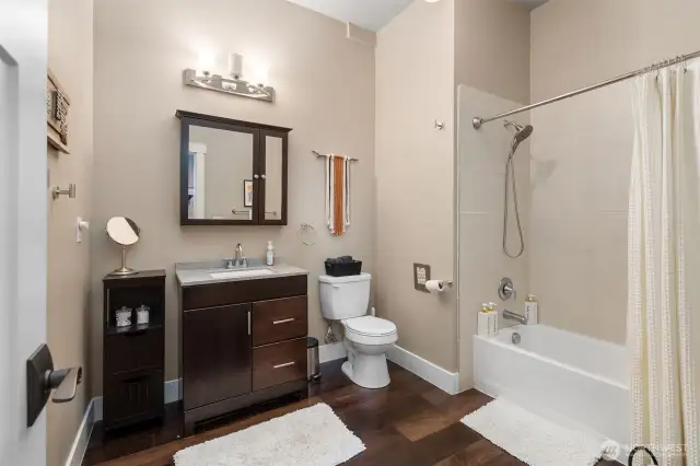 Enjoy plenty of space in this Airbnb full bathroom with high ceilings and a bathtub with shower surround. Matching medicine cabinet mirrors echo the primary suite’s modern look, and the tankless water heater guarantees nonstop hot water throughout the entire home.
