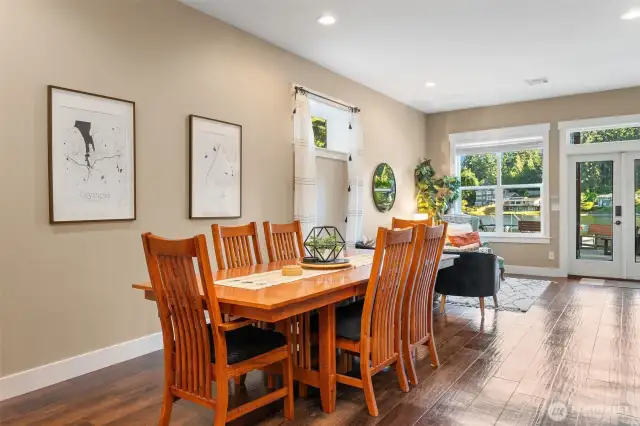 This spacious Airbnb dining room and cozy sitting area overlook the lake, creating a perfect backdrop for meals and relaxing gatherings. French doors lead right out to the patio, making BBQs and lakeside fun effortless and inviting.