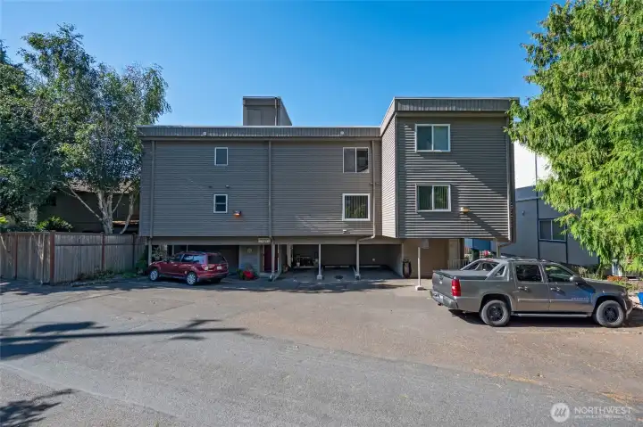 Back of building includes covered parking in carport. Space #4. Security door to the building to the left.