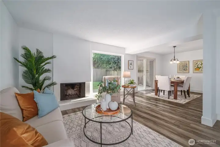 A cozy wood-burning fireplace anchors the living room, which flows seamlessly into the dining area.