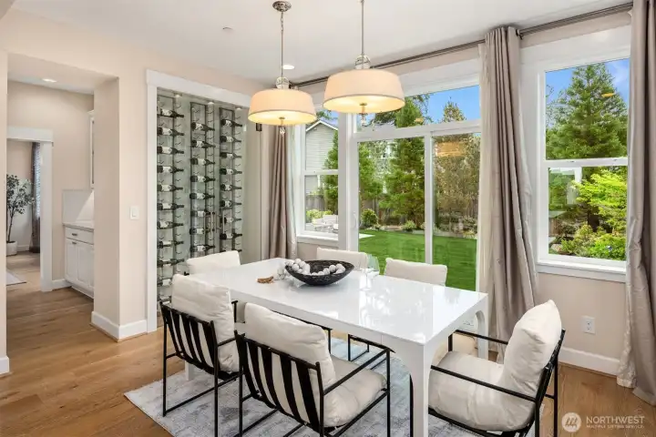 Amazing full-size dining area right by kitchen, glass-enclosed wine display, sliders open up to the serene back yard.