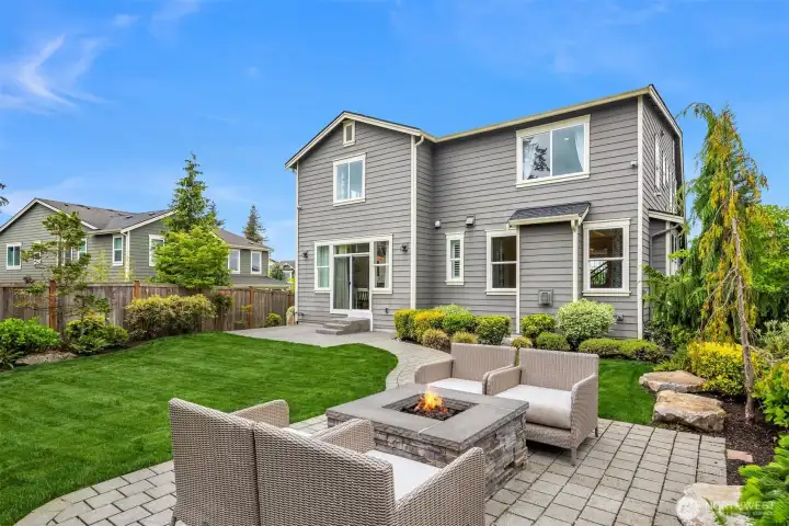 Host your most unforgettable evenings in the lush, landscaped backyard, by this a stone façade gas firepit!