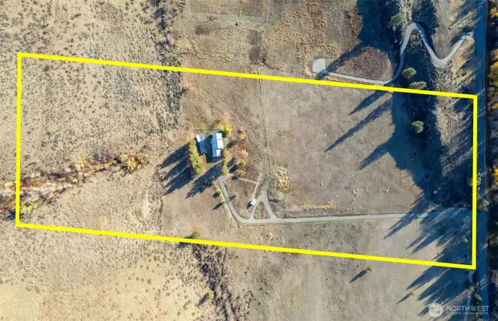 The property is flanked by a natural rock outcropping and protected public land. (Approximate boundary in yellow)