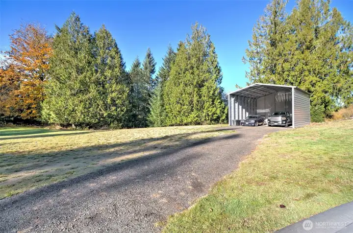 Driveway in to the RV carport with 14' sides. Power is in the street, it has a share of the 2-party well next door, and an installed 3-bedroom septic system. Bring your dream house plans and get started RIGHT AWAY!
